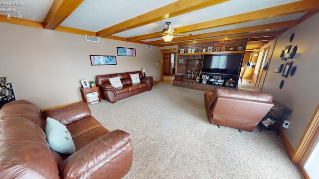 carpeted living room with ceiling fan and beamed ceiling