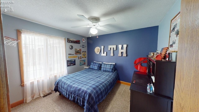 bedroom featuring carpet flooring, a textured ceiling, and ceiling fan