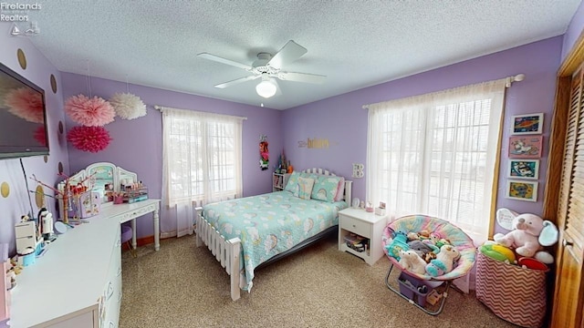 carpeted bedroom with a textured ceiling and ceiling fan