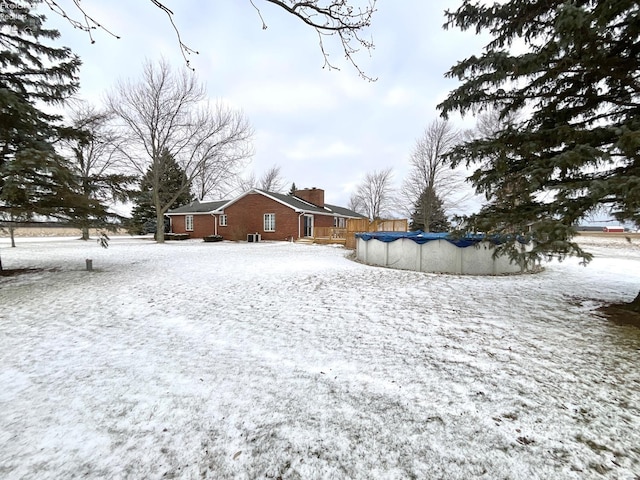 snowy yard featuring a covered pool