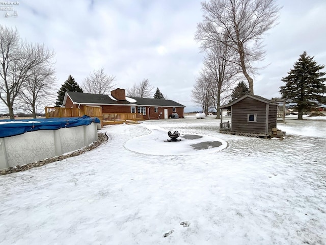 yard layered in snow featuring a wooden deck