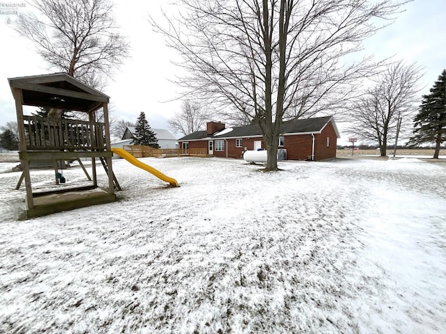 yard layered in snow with a playground