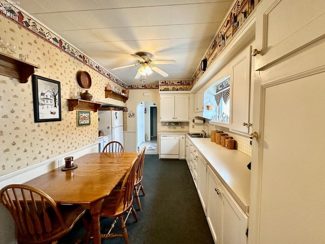 carpeted dining room featuring ceiling fan and sink