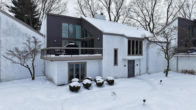 snow covered property with a balcony