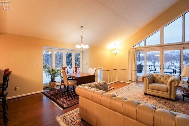 living room featuring a notable chandelier, dark hardwood / wood-style flooring, and lofted ceiling