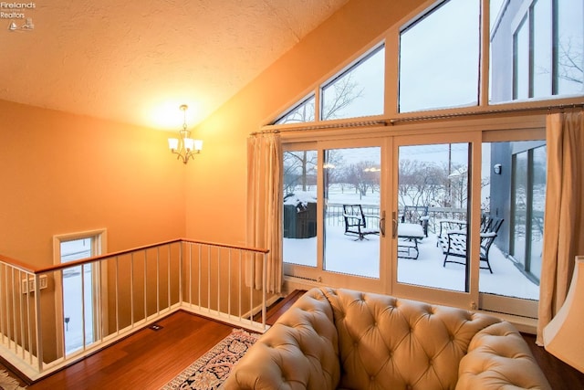 interior space with hardwood / wood-style flooring, plenty of natural light, vaulted ceiling, and an inviting chandelier