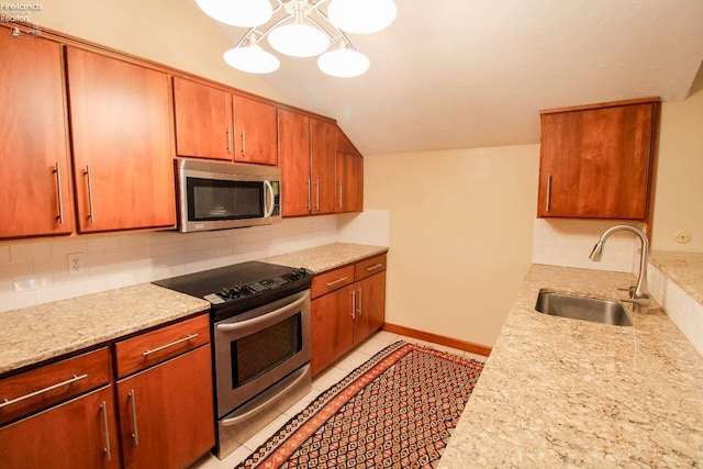 kitchen featuring sink, decorative backsplash, light tile patterned floors, appliances with stainless steel finishes, and light stone counters