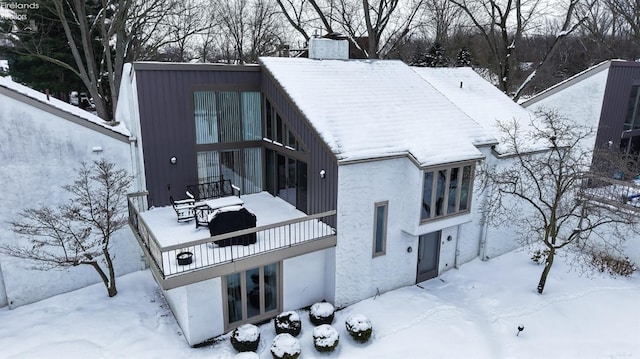 view of snow covered rear of property