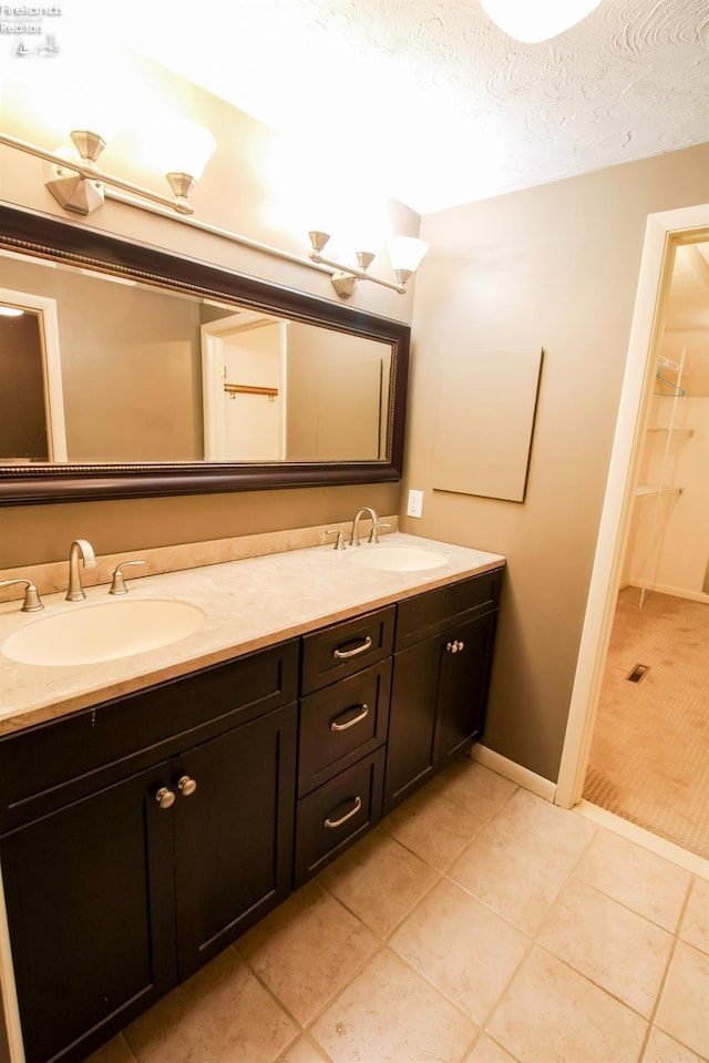 bathroom with tile patterned floors, vanity, and a textured ceiling