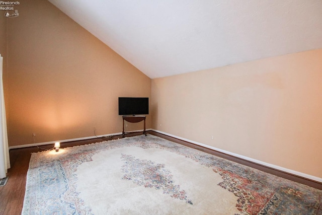 unfurnished living room featuring vaulted ceiling and hardwood / wood-style flooring