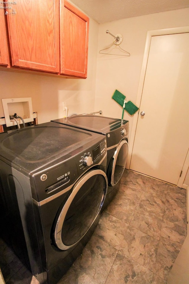 washroom with cabinets and washer and dryer