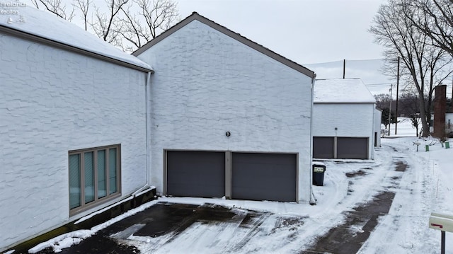 snow covered property featuring a garage