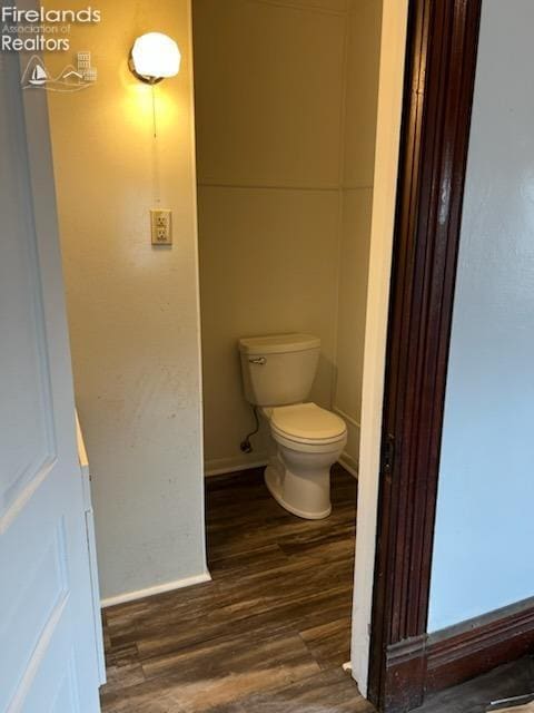 bathroom featuring wood-type flooring and toilet