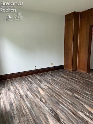 spare room featuring dark wood-type flooring