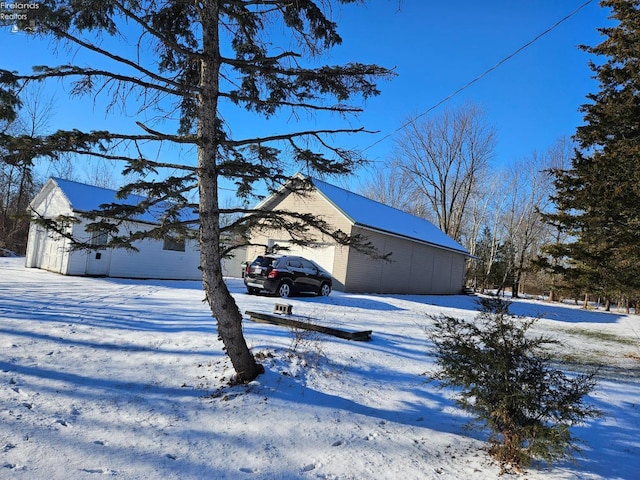 view of snow covered exterior featuring a garage