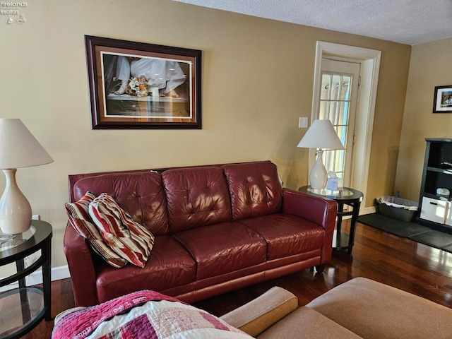 living room with a textured ceiling and dark wood-type flooring