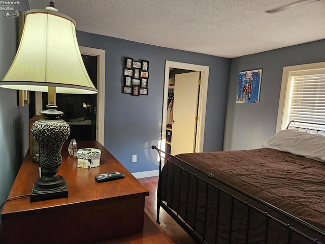 bedroom with hardwood / wood-style floors and a textured ceiling