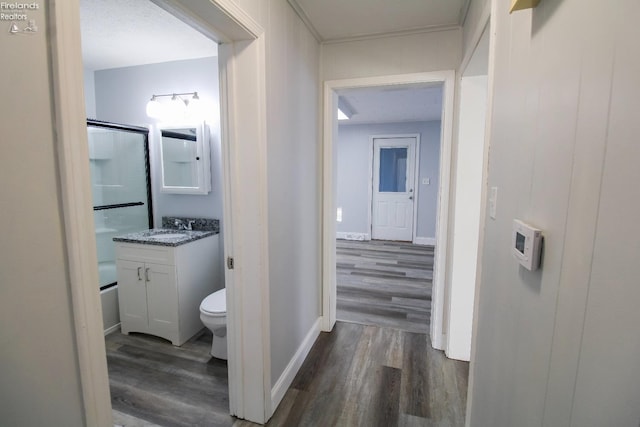 corridor featuring a textured ceiling, dark hardwood / wood-style flooring, and sink