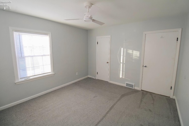 empty room featuring carpet flooring and ceiling fan