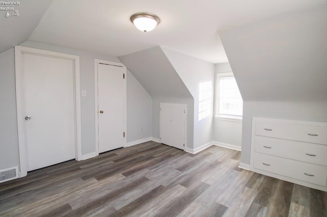 additional living space featuring lofted ceiling and hardwood / wood-style flooring