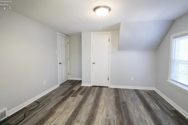 bonus room with dark wood-type flooring and lofted ceiling