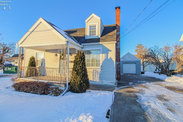 view of front of house featuring a porch, a garage, and an outdoor structure