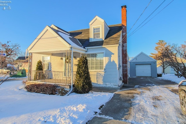 view of front of home with an outbuilding, covered porch, and a garage