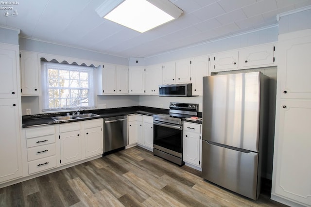 kitchen with white cabinets, sink, stainless steel appliances, and dark wood-type flooring