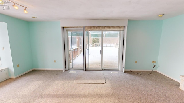 carpeted spare room with track lighting