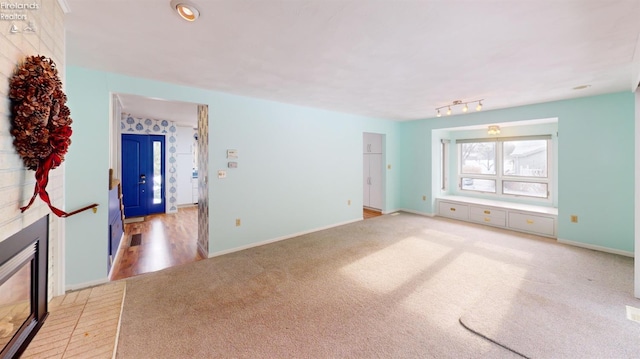 empty room featuring light colored carpet and a fireplace