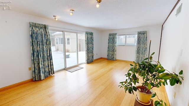 spare room with hardwood / wood-style flooring and a textured ceiling