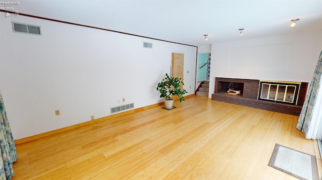 living room with hardwood / wood-style flooring and a brick fireplace