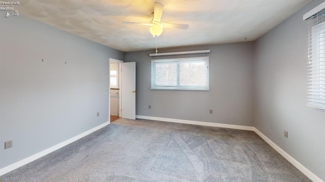 carpeted spare room featuring ceiling fan