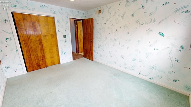 unfurnished bedroom featuring carpet floors and a closet