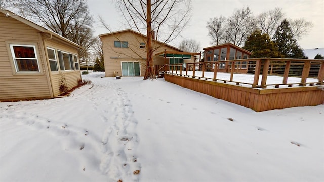 yard layered in snow featuring a deck