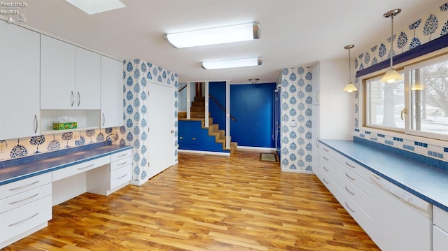 kitchen featuring decorative backsplash, white cabinetry, and light wood-type flooring