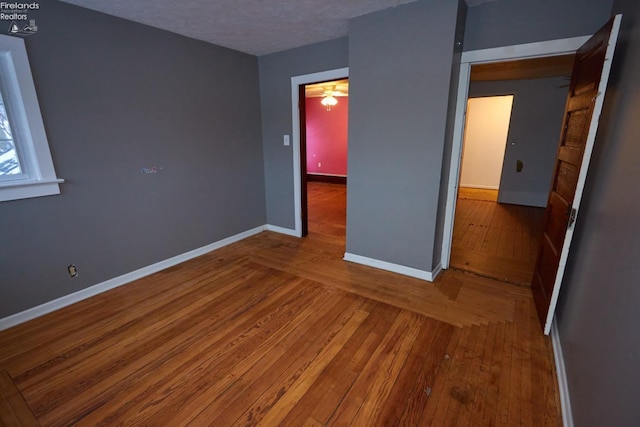 unfurnished bedroom with hardwood / wood-style floors and a textured ceiling