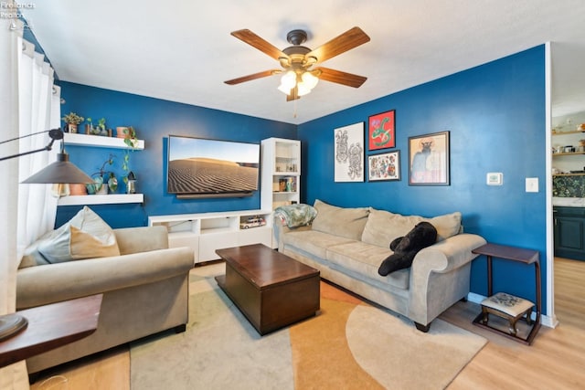 living room with ceiling fan and light hardwood / wood-style flooring