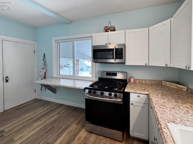 kitchen featuring stainless steel appliances, dark hardwood / wood-style flooring, white cabinets, and light stone counters