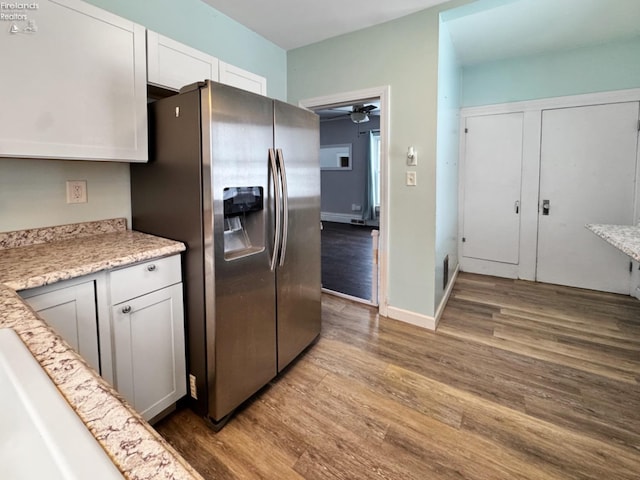 kitchen with ceiling fan, white cabinets, wood-type flooring, and stainless steel fridge with ice dispenser