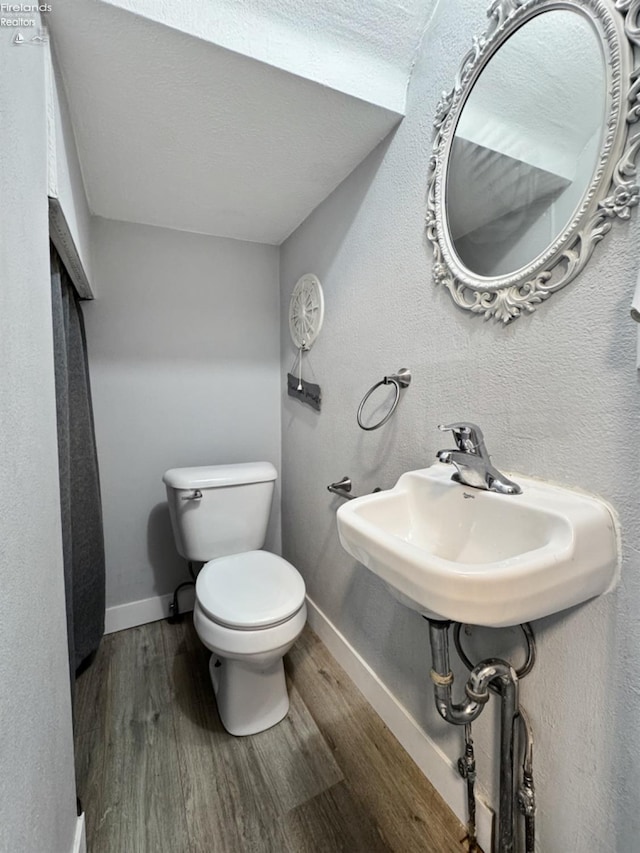 bathroom with toilet, hardwood / wood-style flooring, and sink