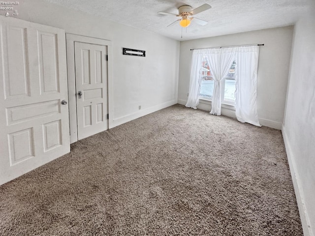 carpeted empty room with ceiling fan and a textured ceiling