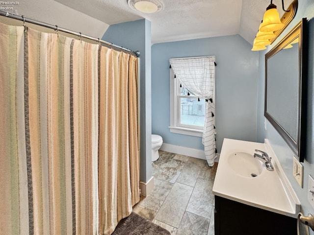 bathroom with lofted ceiling, vanity, toilet, a shower with curtain, and a textured ceiling