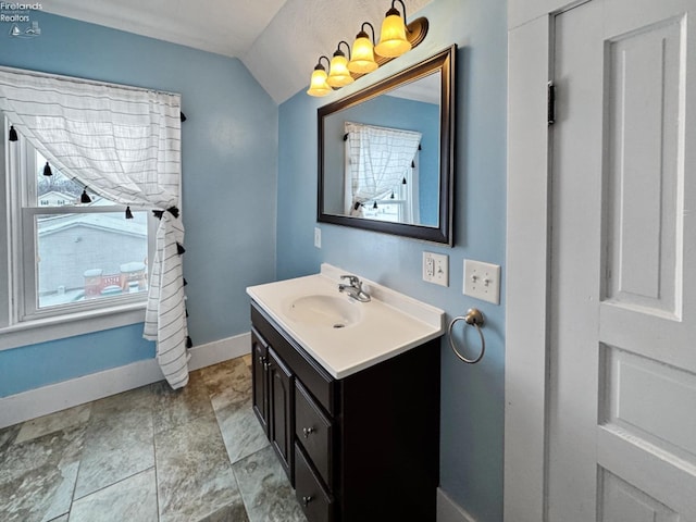 bathroom featuring vanity and lofted ceiling