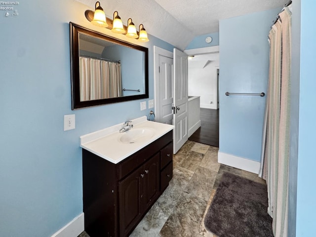 bathroom with lofted ceiling, vanity, and a textured ceiling