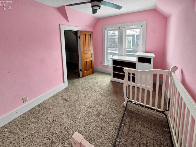 bedroom featuring ceiling fan, vaulted ceiling, a textured ceiling, and carpet flooring