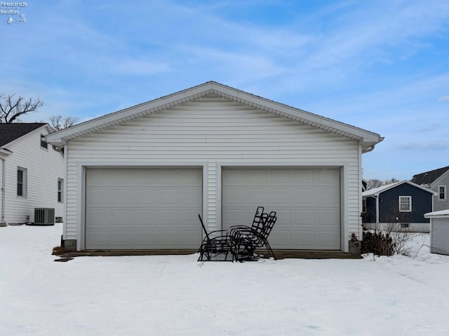 snow covered garage with central AC