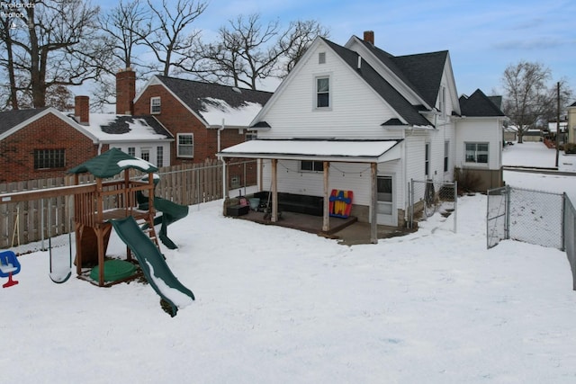 snow covered property featuring a playground