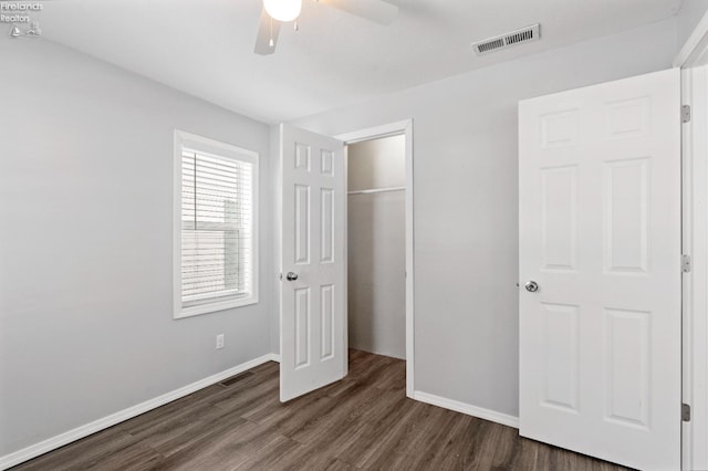 unfurnished bedroom featuring ceiling fan, dark hardwood / wood-style floors, and a closet