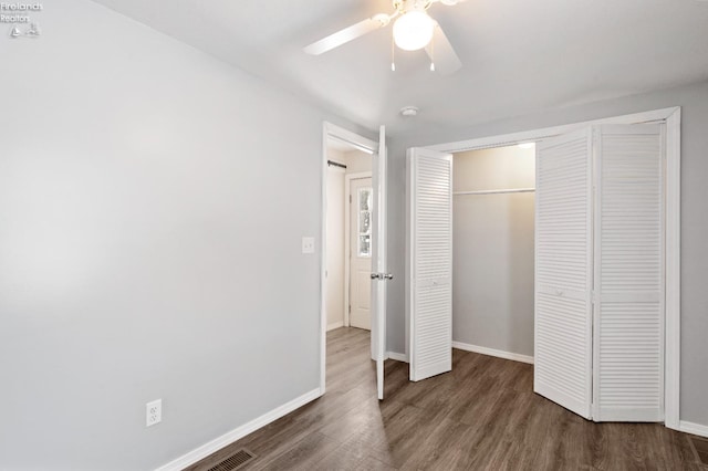 unfurnished bedroom featuring ceiling fan, dark hardwood / wood-style floors, and a closet